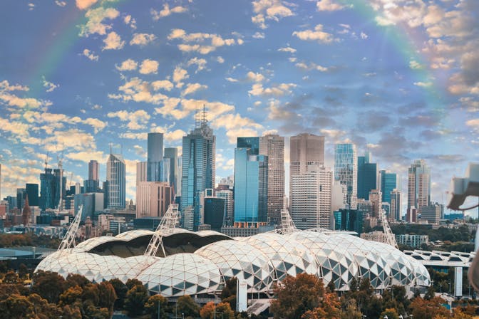 A view of the CBD with a rainbow in a blue sky.